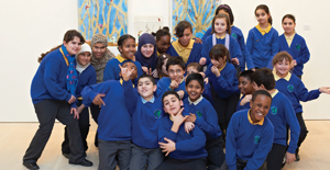 A group of primary-school children in blue school uniform in an art gallery